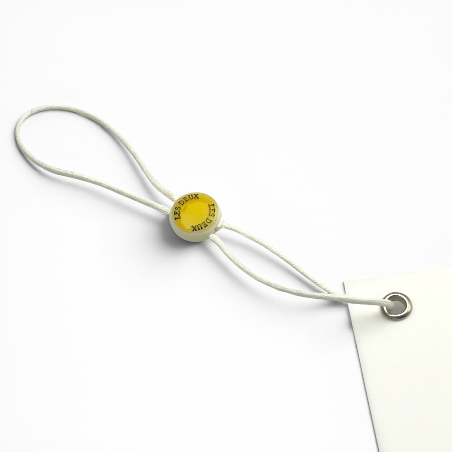 Round white garment seal tag with yellow logo and white string