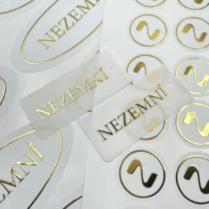 Білі наліпки та бірки із золотим написом NEZEMNÍ.