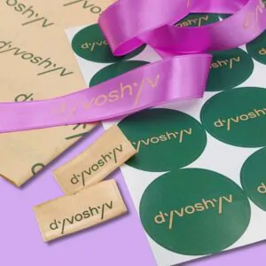 Фіолетова стрічка, зелені наліпки та бірки з логотипом.