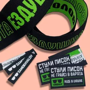 Чорні текстильні стрічки та етикетки з яскравим зеленим друком